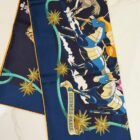 Hermès Les Mustangs II double face silk scarf 90, folded with orange rolled hem