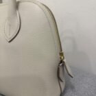 Hermès Mini Bolide in Beton Evercolor leather, close up of grain, handle and gold zip
