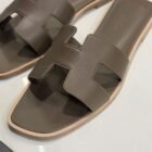 Hermès Oran sandal in Etoupe Swift leather, close up of the H cut out strap