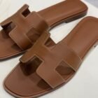 Hermès Oran sandal in Gold Swift leather, close up of the H cut out strap and stitching