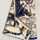 Hermès Stately Wheels silk scarf 90 in crème, bordeaux and bleu, folded