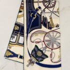 Hermès Stately Wheels silk scarf 90, folded to show the carriage wheel and coachman print